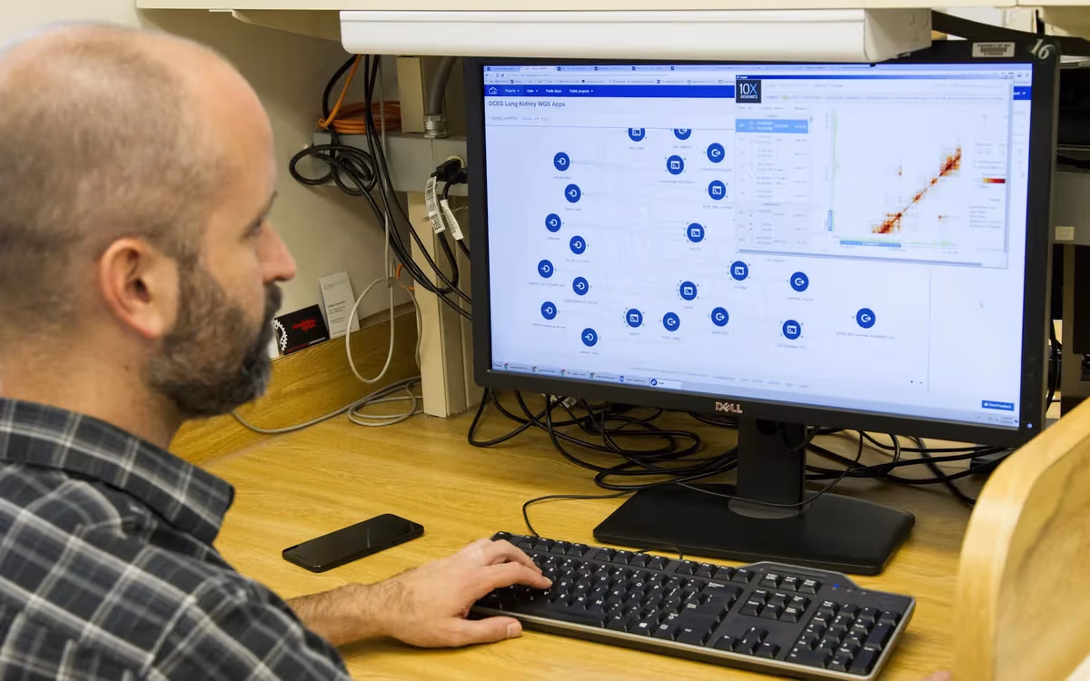 Bioinformatician analyzing genomic data at a multi-monitor workstation