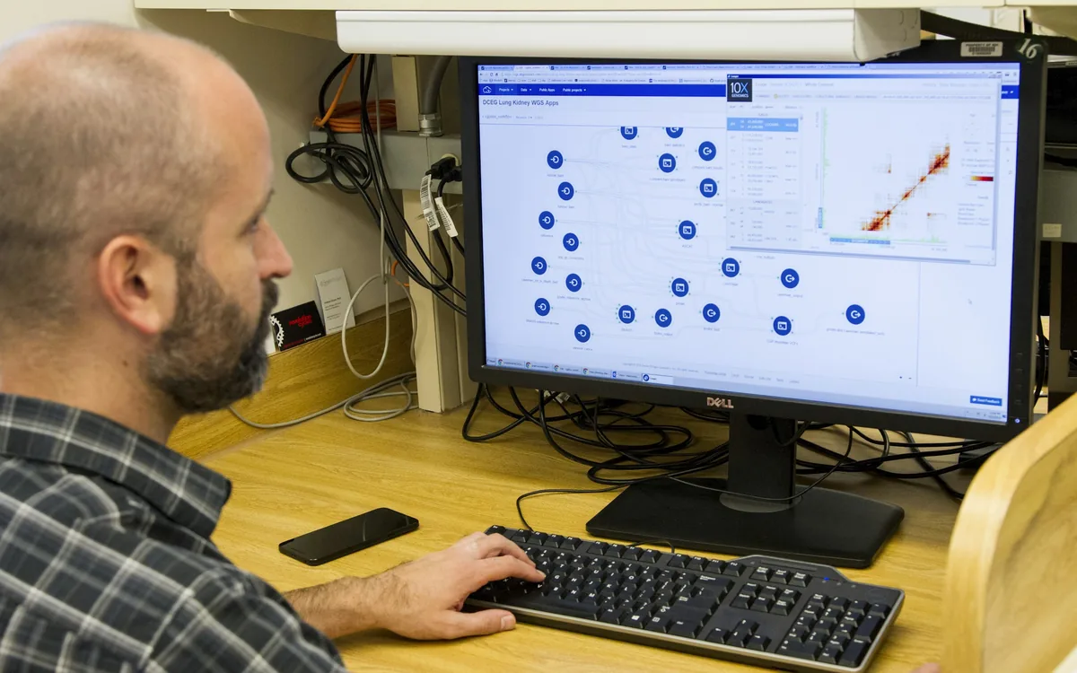 Bioinformatician analyzing genomic data at a multi-monitor workstation