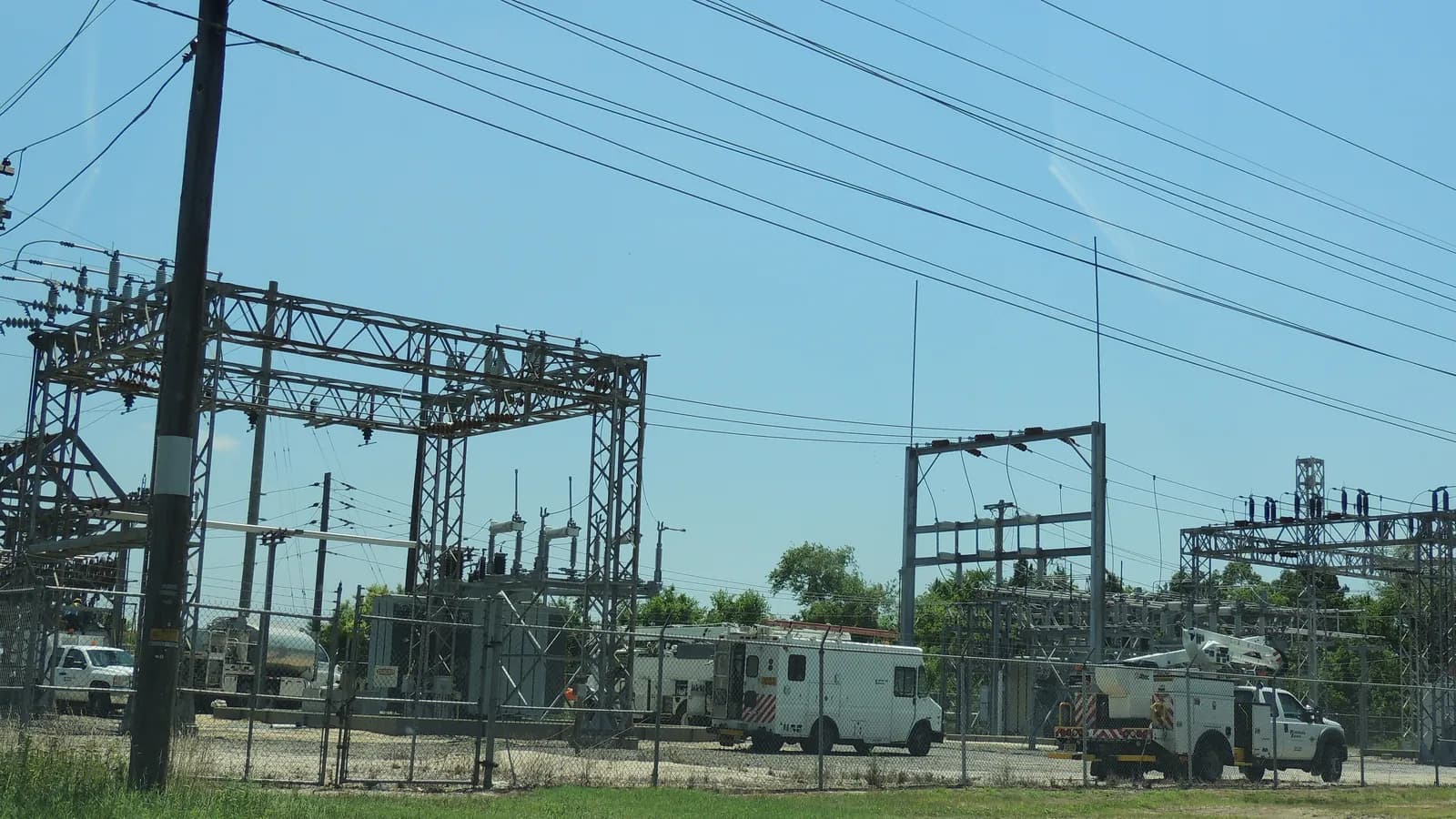 Utility trucks parked inside the fenced Rio Grande substation in New Jersey during maintenance work; boxes mark three of the trucks.