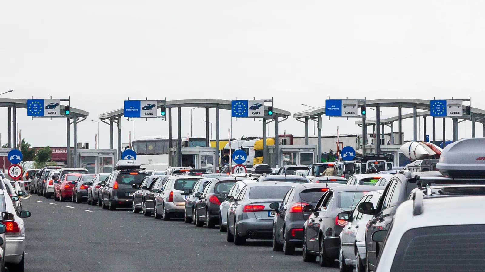 Cars queue at the passport control booths on the Romanian side of the Nădlac and Nagylak crossing between Romania and Hungary; boxes mark 21 cars and a coach.