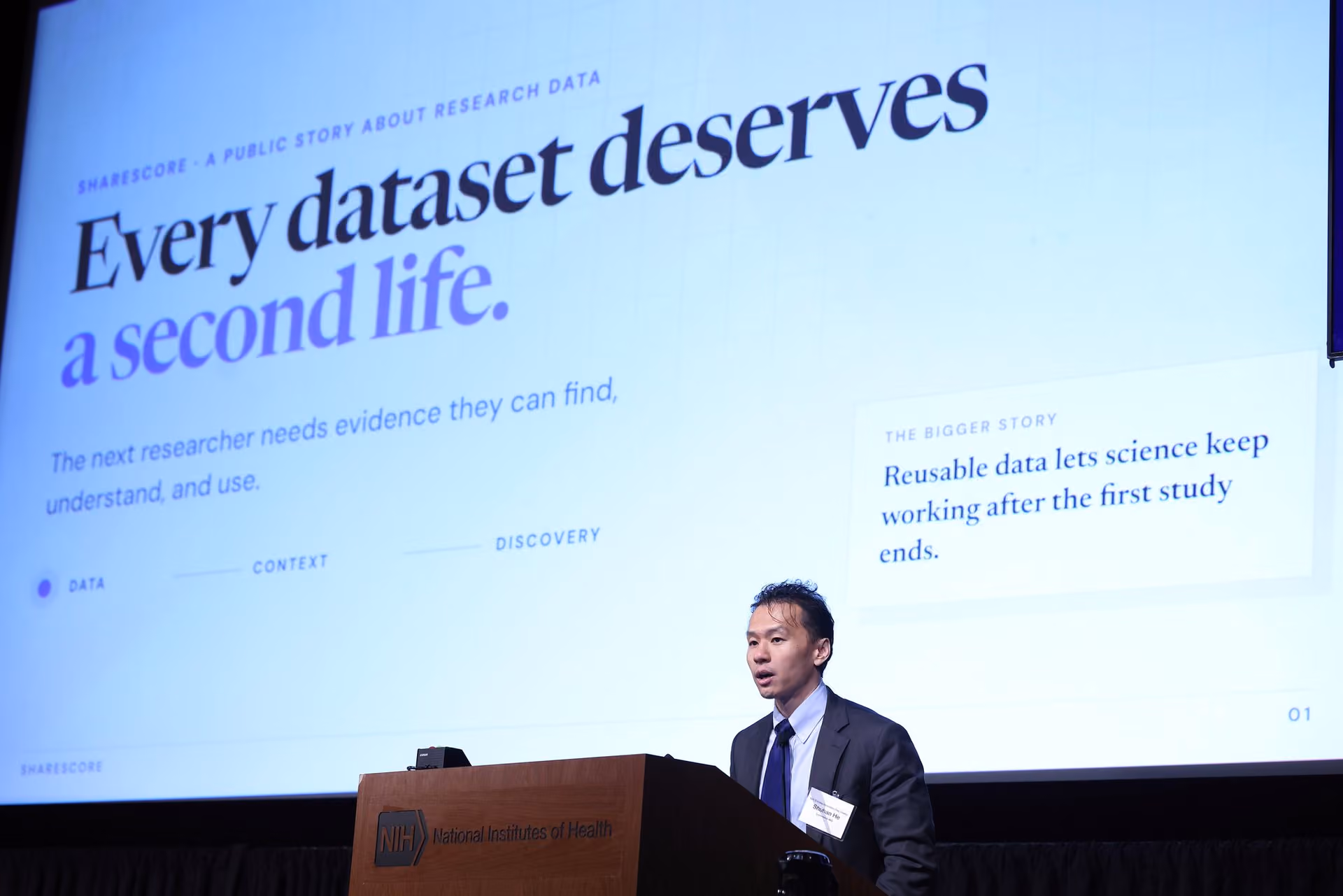 Shuhan He at an NIH podium in front of a slide reading Every dataset deserves a second life