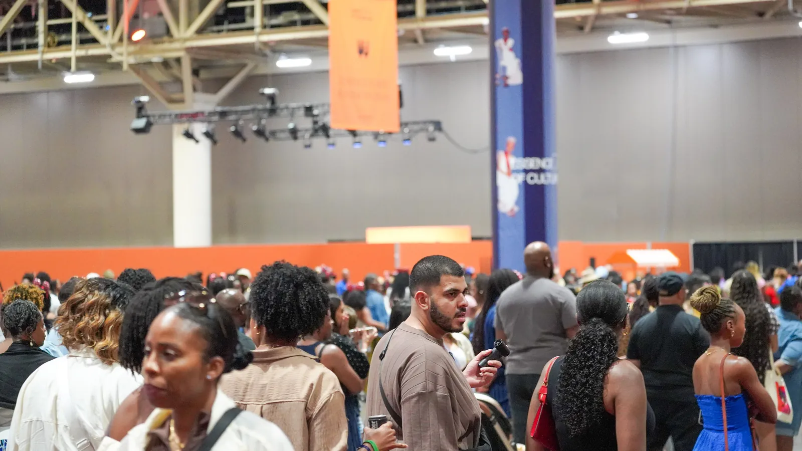 A dense crowd fills the floor of a convention hall during a culture festival; boxes mark 22 people.