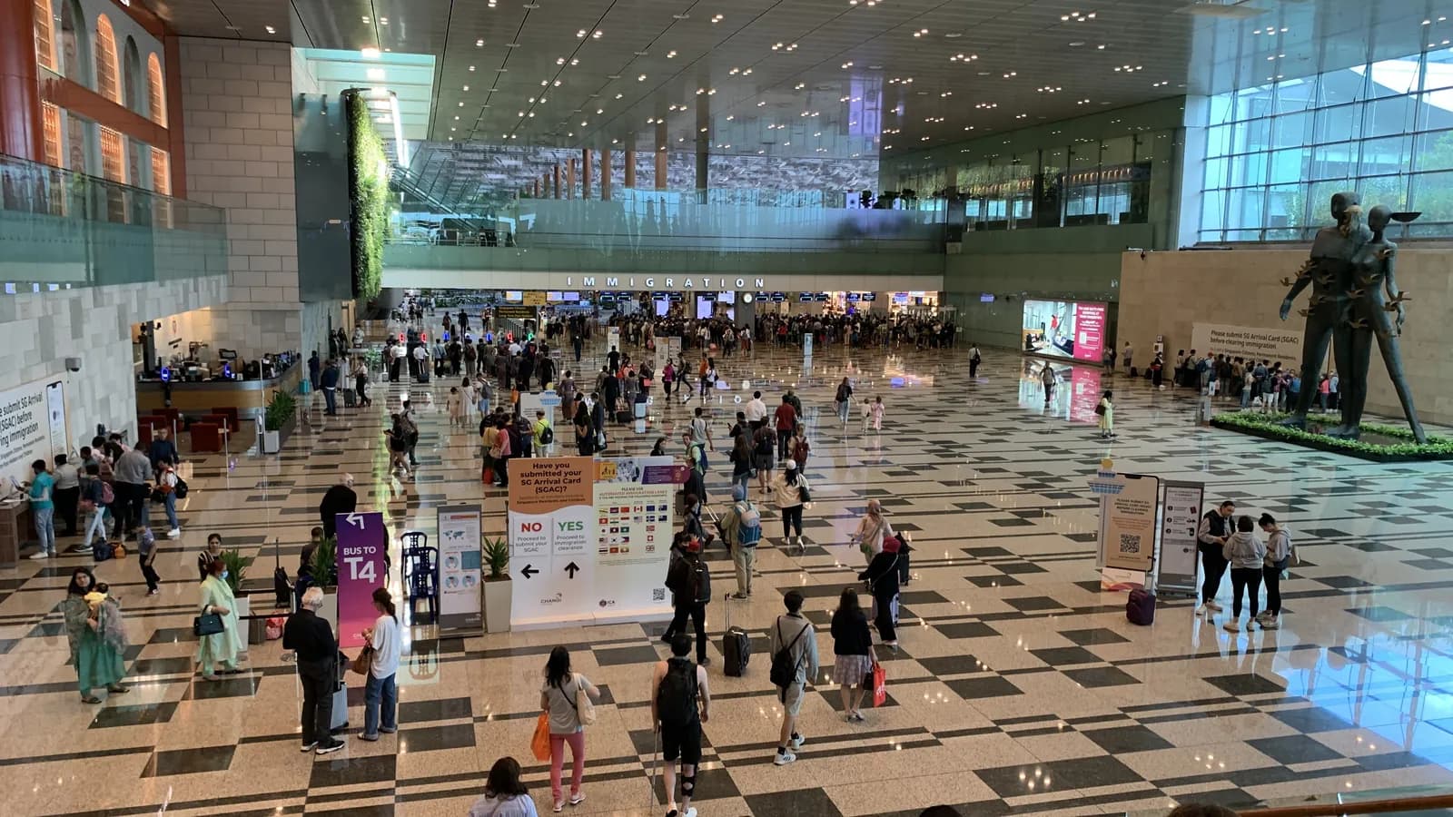 Arriving travelers cross the hall in front of the immigration counters at Changi Airport Terminal 3 in Singapore; boxes mark 32 people.