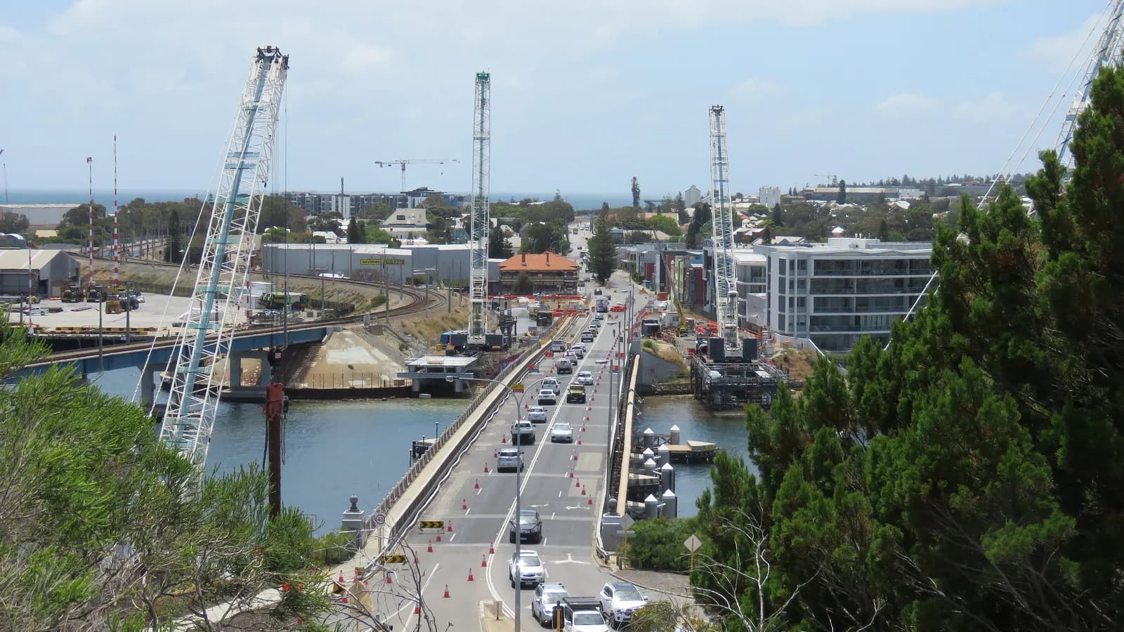 Traffic crosses the Fremantle Traffic Bridge in Western Australia beside the cranes building its replacement, seen from Cantonment Hill; boxes mark 22 cars and 2 trucks.