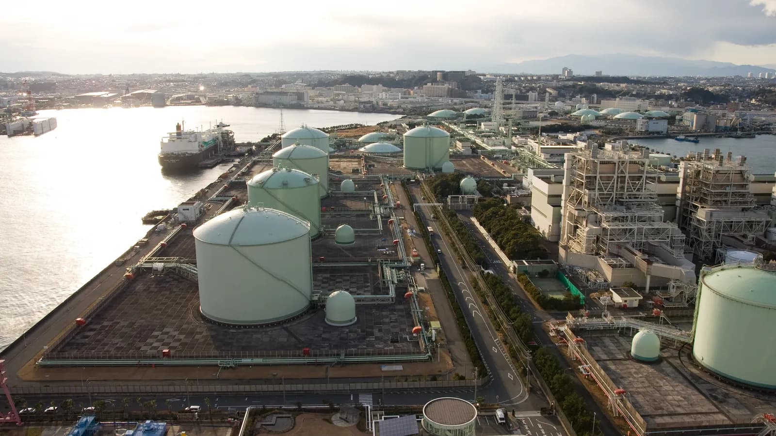 A ship berthed beside the storage tanks of the Negishi LNG Terminal in Yokohama, Japan; boxes and outlines mark the ship and five storage tanks.