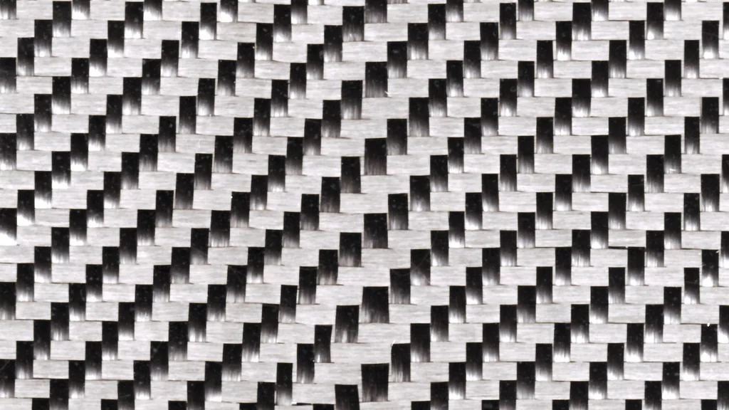 Woven carbon-fiber fabric in a twill weave: aligned fiber tows crossing in warp and weft directions, the oriented bundles measured for composite fiber orientation