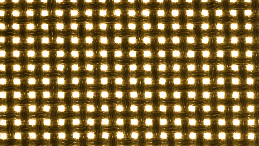 Backlit plain-weave fabric with bright square openings between the yarns, showing the optical open area of the weave