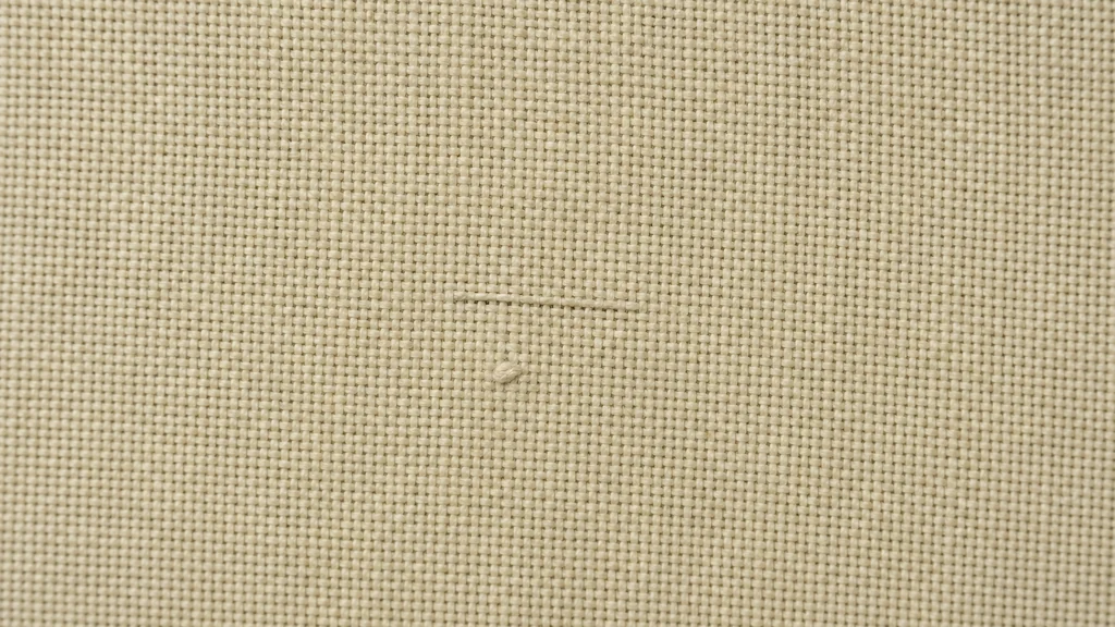 Woven cotton fabric on an inspection surface with a small weaving defect near the center