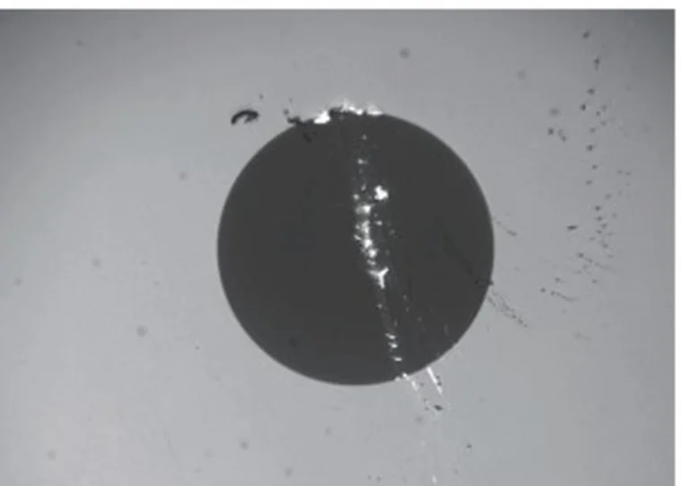 Fiber optic connector end-face under inspection microscope: the fiber core disc with a scratch across it