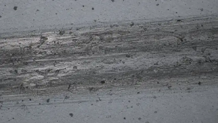 Worn material surface with scratches and debris for roughness analysis